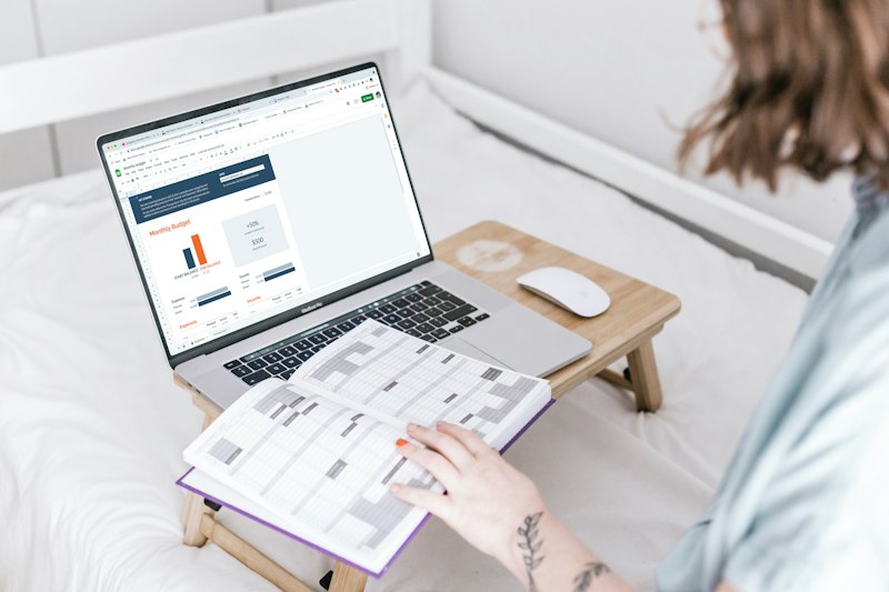 A person sitting on a bed with a laptop